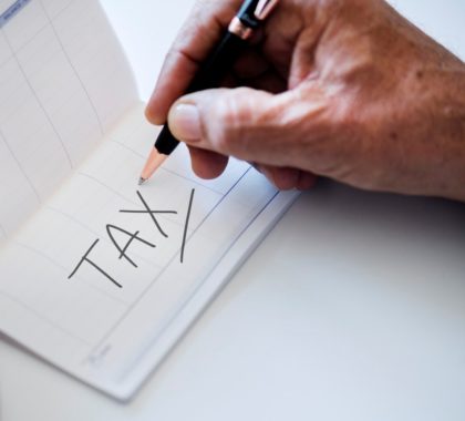 Male Hand Writing the Word 'Tax' in a Calendar