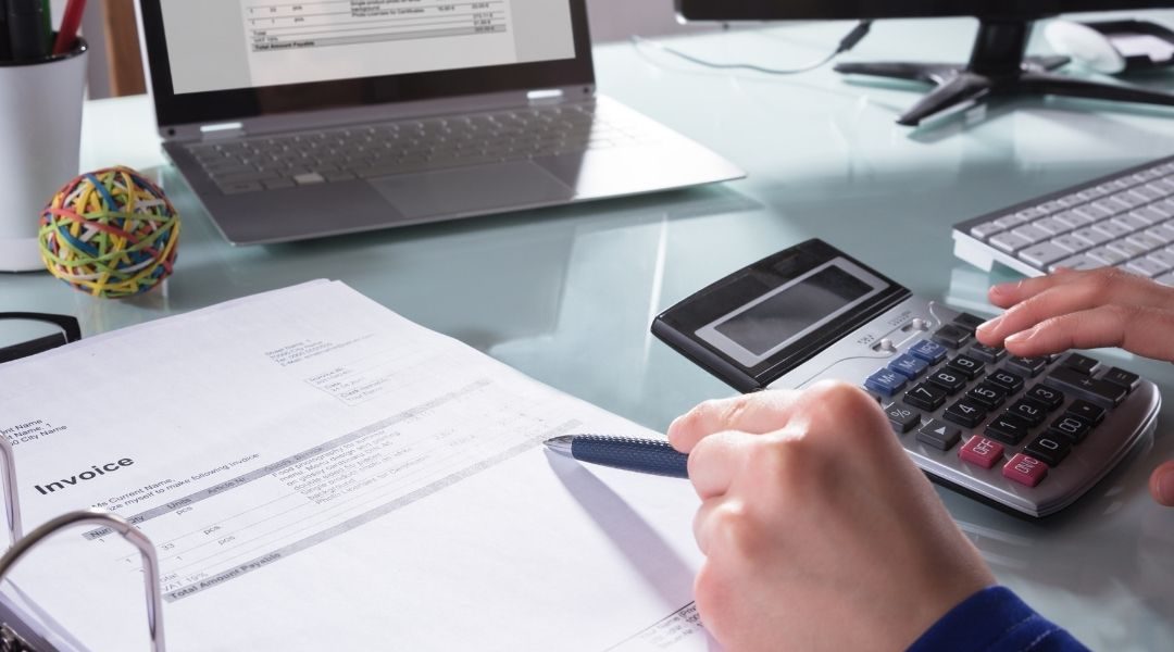 Bookkeeper using a calculator | Featured image Do I Need a Bookkeeper? 6 Signs You Might Blog