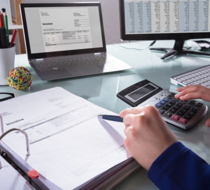 Bookkeeper using a calculator | Featured image Do I Need a Bookkeeper? 6 Signs You Might Blog